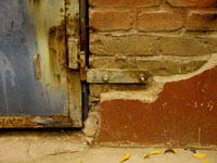 old door hinge on brick wall